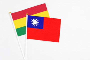 Taiwan and Bolivia stick flags on white background. High quality fabric, miniature national flag. Peaceful global concept.White floor for copy space.