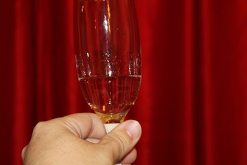 champagne glasses in hand on red background