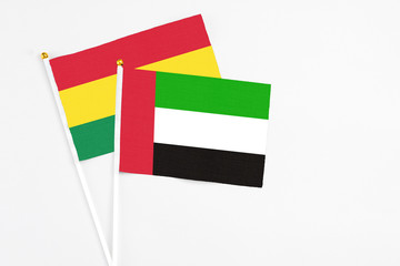 United Arab Emirates and Bolivia stick flags on white background. High quality fabric, miniature national flag. Peaceful global concept.White floor for copy space.