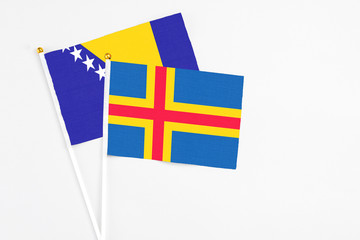 Aland Islands and Bosnia Herzegovina stick flags on white background. High quality fabric,...