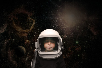 a small child imagines himself to be an astronaut in an astronaut's helmet.