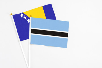 Botswana and Bosnia Herzegovina stick flags on white background. High quality fabric, miniature...