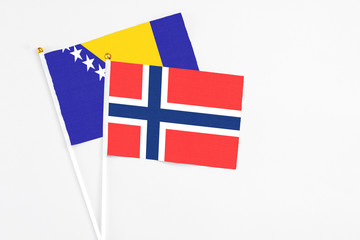 Bouvet Islands and Bosnia Herzegovina stick flags on white background. High quality fabric, miniature national flag. Peaceful global concept.White floor for copy space.