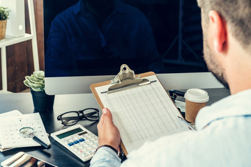 Young man businessman sitting at his working table in office