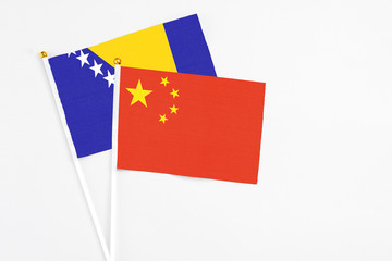 China and Bosnia Herzegovina stick flags on white background. High quality fabric, miniature national flag. Peaceful global concept.White floor for copy space.