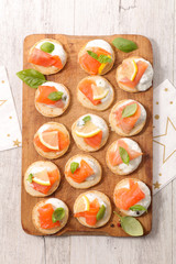 wooden board with canape, cheese and salmon