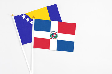 Dominican Republic and Bosnia Herzegovina stick flags on white background. High quality fabric, miniature national flag. Peaceful global concept.White floor for copy space.