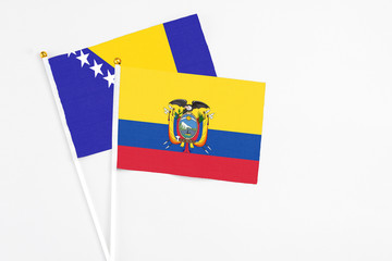 Ecuador and Bosnia Herzegovina stick flags on white background. High quality fabric, miniature national flag. Peaceful global concept.White floor for copy space.
