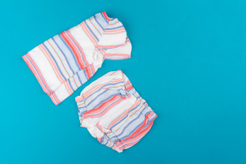 baby clothes on blue  background top view