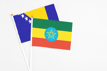 Ethiopia and Bosnia Herzegovina stick flags on white background. High quality fabric, miniature national flag. Peaceful global concept.White floor for copy space.