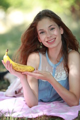 Jolie jeune femme allongée mangeant une banane