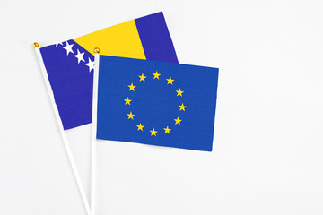 European Union and Bosnia Herzegovina stick flags on white background. High quality fabric, miniature national flag. Peaceful global concept.White floor for copy space.