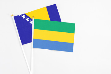 Gabon and Bosnia Herzegovina stick flags on white background. High quality fabric, miniature...