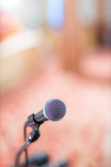 Fototapeta premium microphone in concert hall or conference room soft and blur style for background.Microphone over the Abstract blurred photo of conference hall or seminar room background.