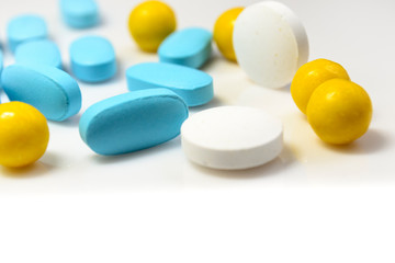 Fototapeta na wymiar blue, yellow pills on a white background close-up