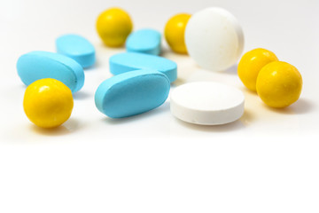 blue, yellow pills on a white background close-up