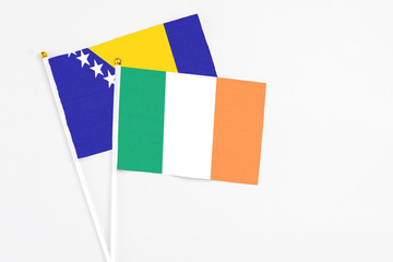 Fototapeta premium Ireland and Bosnia Herzegovina stick flags on white background. High quality fabric, miniature national flag. Peaceful global concept.White floor for copy space.