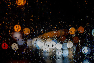 rainy night,rain drops on the window and colorful traffic bokeh light