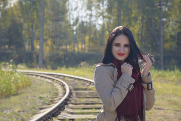 Fototapeta na wymiar Young, caucasian girl walking on the railway. Railroad workers doing their job. Rail advertising