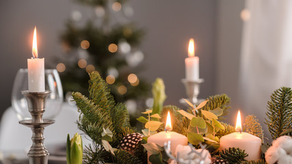 fragments of Christmas decor, cones, candles on the background of a decorated Christmas tree