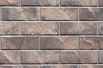 Brown stone siding tile wall abstract background. House exterior with blocks. Crafted outer wall