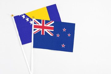 Fototapeta premium New Zealand and Bosnia Herzegovina stick flags on white background. High quality fabric, miniature national flag. Peaceful global concept.White floor for copy space.
