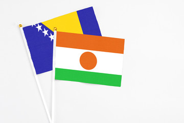 Niger and Bosnia Herzegovina stick flags on white background. High quality fabric, miniature...