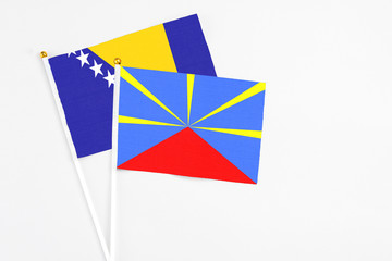 Reunion and Bosnia Herzegovina stick flags on white background. High quality fabric, miniature...