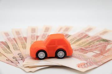 buying a car in rubles toy car on the background of banknotes.