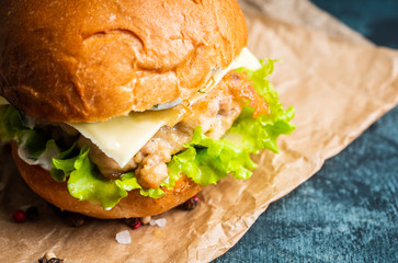 Fresh tasty burgers with roasted turkey cutlet, salad, cheese and different herbs on the rustic background. Selective focus. Shallow depth of field.