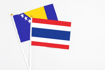 Obraz premium Thailand and Bosnia Herzegovina stick flags on white background. High quality fabric, miniature national flag. Peaceful global concept.White floor for copy space.