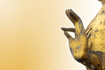 hand of the large thai buddha statue in attijude of meditation with  orange light background in the morning, art of religion concept.