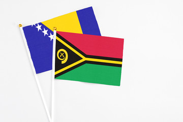 Vanuatu and Bosnia Herzegovina stick flags on white background. High quality fabric, miniature national flag. Peaceful global concept.White floor for copy space.