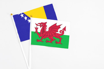 Wales and Bosnia Herzegovina stick flags on white background. High quality fabric, miniature national flag. Peaceful global concept.White floor for copy space.