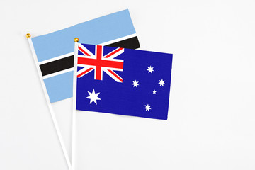 Fototapeta premium Australia and Botswana stick flags on white background. High quality fabric, miniature national flag. Peaceful global concept.White floor for copy space.