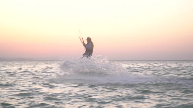 High jump performed by a kite surfer, release trick, aerial stunt, colorful sky