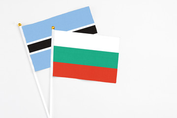 Bulgaria and Botswana stick flags on white background. High quality fabric, miniature national flag. Peaceful global concept.White floor for copy space.