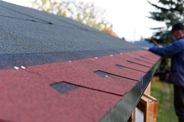 Modern roof shingles tiles. Soft asphalt roof cover and roofing construction for a small house in...