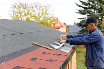 Modern roof shingles tiles. Soft asphalt roof cover and roofing construction for a small house in...