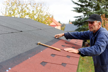 Modern roof shingles tiles. Soft asphalt roof cover and roofing construction for a small house in...