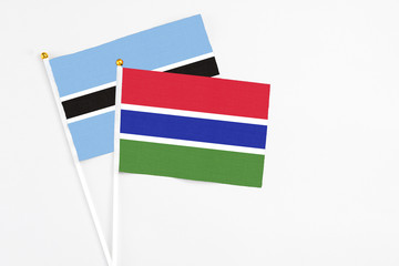 Gambia and Botswana stick flags on white background. High quality fabric, miniature national flag. Peaceful global concept.White floor for copy space.