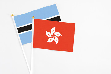 Hong Kong and Botswana stick flags on white background. High quality fabric, miniature national flag. Peaceful global concept.White floor for copy space.