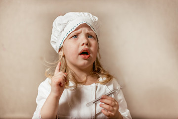 little girl with a thermometer in a nurse costume moralistically threatens a finger