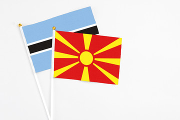 Macedonia and Botswana stick flags on white background. High quality fabric, miniature national flag. Peaceful global concept.White floor for copy space.