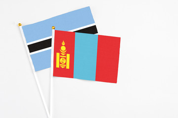 Mongolia and Botswana stick flags on white background. High quality fabric, miniature national flag. Peaceful global concept.White floor for copy space.