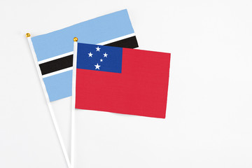 Samoa and Botswana stick flags on white background. High quality fabric, miniature national flag. Peaceful global concept.White floor for copy space.