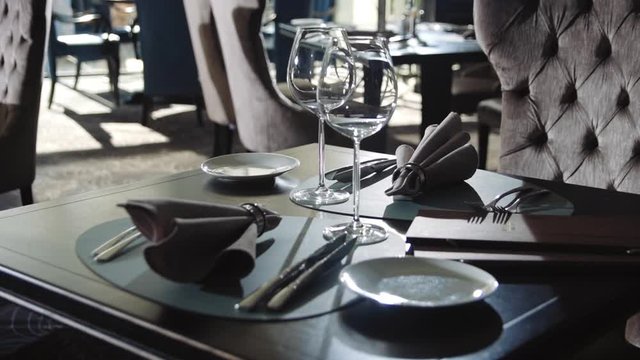 Wine glass and plate for dinner in restaurant. Tableware set on dining table