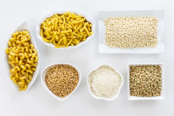 White plates with noodles, rice, Israeli couscous, and lentils.