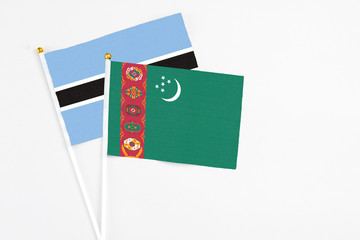 Turkmenistan and Botswana stick flags on white background. High quality fabric, miniature national flag. Peaceful global concept.White floor for copy space.