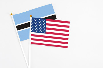 United States and Botswana stick flags on white background. High quality fabric, miniature national flag. Peaceful global concept.White floor for copy space.